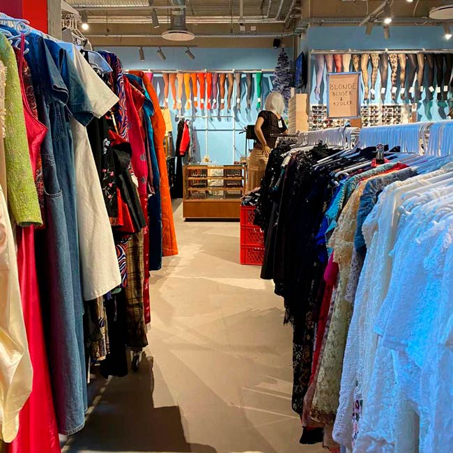 Tøjstativer fyldt med tøj i butikken PRAG i Amager Centret